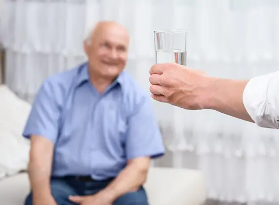 Ger ett glas vatten till den gamla mannen