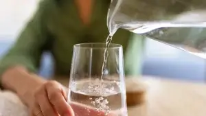 Häller vatten från karaff till glas.